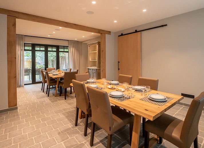 Gezellige woonkamer in Vakantiehuis Huyze Ter Bercken in De Haan, Belgische kust, met moderne inrichting en uitzicht op de tuin.