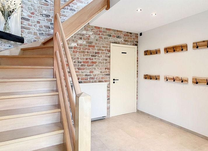 Hoeve Langhof vakantiehuis in De Haan, Belgie met een charmante binnenplaats en rustieke stenen muren.