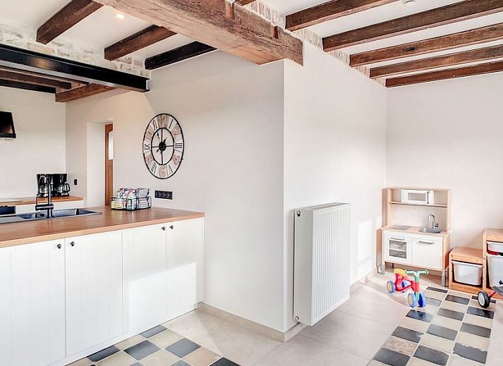 Gezellige entree met houten trap in Hoeve Langhof vakantiehuis, De Haan aan de Belgische kust.