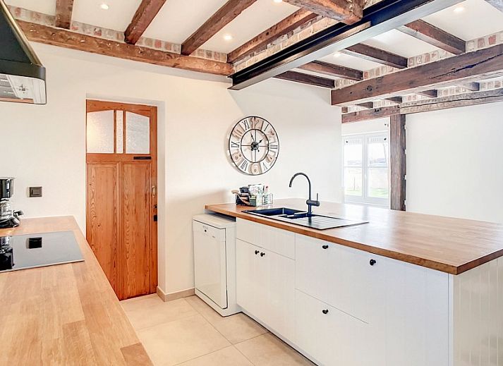 Gezellige entree met houten trap in Hoeve Langhof vakantiehuis, De Haan aan de Belgische kust.