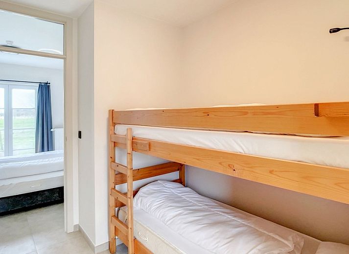 Gezellige entree met houten trap in Hoeve Langhof vakantiehuis, De Haan aan de Belgische kust.
