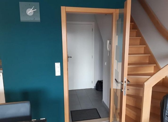 Bright living room in Huize Oesjoe, Bredene with comfortable sofa and large window for natural light.