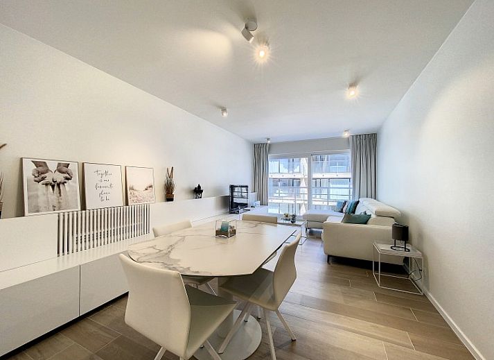 Moderne woonkamer van Studio 'De Zandloper' in Oostduinkerke-bad, Belgische kust, met comfortabele witte bank.