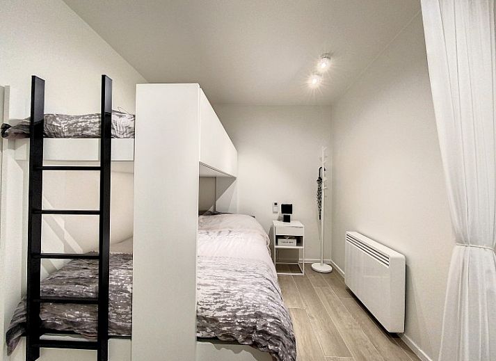 Moderne woonkamer van Studio 'De Zandloper' in Oostduinkerke-bad, Belgische kust, met comfortabele witte bank.