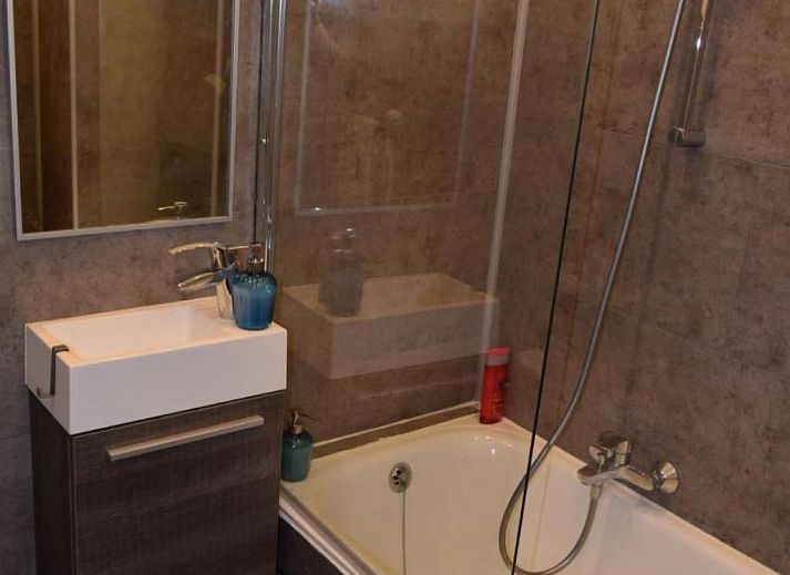 Gezellige woonkamer in Appartement in Woluwe-Saint-Lambert, Brussel met uitzicht op de stad, comfortabele bank en moderne inrichting.