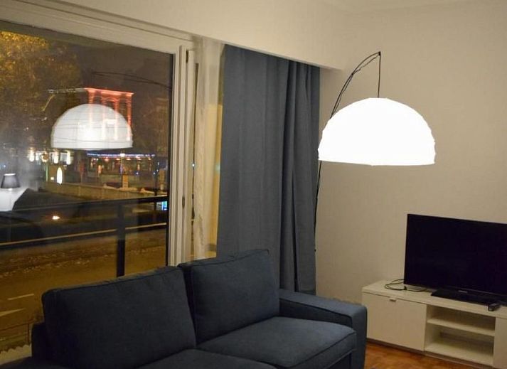 Gezellige woonkamer in Appartement in Woluwe-Saint-Lambert, Brussel met uitzicht op de stad, comfortabele bank en moderne inrichting.