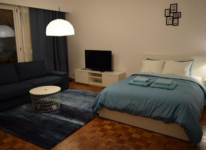 Gezellige woonkamer in Appartement in Woluwe-Saint-Lambert, Brussel met uitzicht op de stad, comfortabele bank en moderne inrichting.