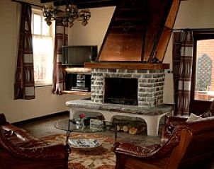 Gezellige woonkamer met open haard in Den Anker vakantiewoning in Houthulst, West-Vlaanderen.