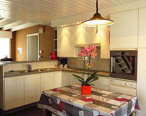 Ruime woonkamer in Hof ter Harte vakantiehuis, Ieper, West-Vlaanderen met comfortabele banken en open haard.