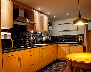 Volledig uitgeruste keuken in Huis 7, vakantiehuis Ieper, West-Vlaanderen, met houten kasten.