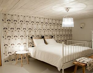 Lichte slaapkamer met wit bed in Huis 7, vakantiehuis Ieper, West-Vlaanderen.