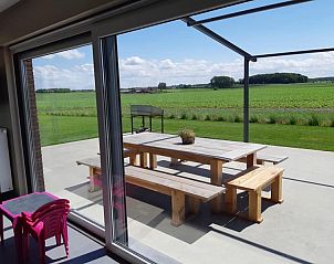 Zonnig terras met picknicktafel bij 't Amusement vakantiehuis, Ieper.