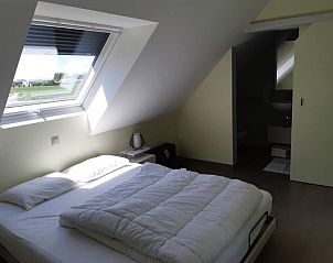 Lichte slaapkamer met dakraam in 't Amusement, Ieper, West-Vlaanderen.