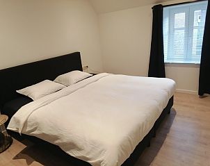 Ruime slaapkamer met groot bed in THE FRONT DOOR N28, vakantiehuis in Ieper, West-Vlaanderen.