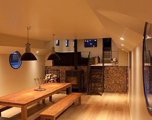Eetruimte in Bed in Boat, Ieper, met houten tafel en gezellige sfeer voor diners.