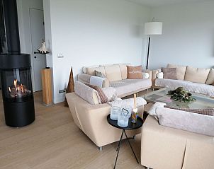 Cozy living room in Holiday home Ferienvilla 'Wellness Akkerland', Zonnebeke, West Flanders, with fireplace and comfortable sofas.