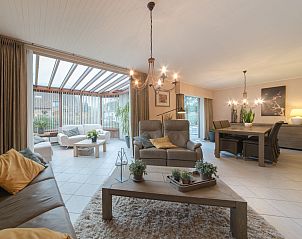 Gezellige woonkamer van Vakantiehuis Villa Kievit in De Haan, West-Vlaanderen, met comfortabele zithoek en veel natuurlijk licht.