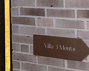 Ferienhaus in Westouter, Westflandern, Belgien, mit einer charmanten Backsteinmauer und einem Schild fr einen einladenden Aufenthalt.