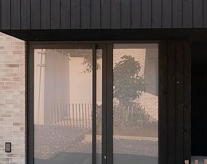 Moderne Fassade von Holiday home in Westouter, einem stilvollen Ferienhaus in Westflandern, Belgien, mit einer einladenden Glasschiebetr.