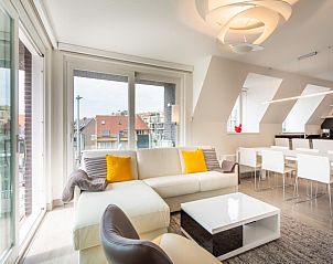 Helles Wohnzimmer des Ferienhauses Aim 303 in Koksijde, Westflandern, mit moderner Einrichtung und Stadtblick.
