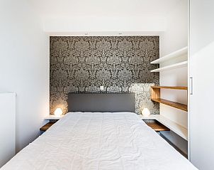 Attraktives Schlafzimmer im Ferienhaus Aim 303, Koksijde, mit eleganter Tapete und moderner Einrichtung in Westflandern, Belgien.