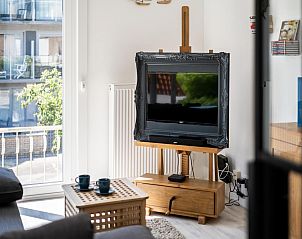 Gemtliches Wohnzimmer im Ferienhaus Argenteuil Two, Koksijde, mit stilvoller Einrichtung und Blick auf die sonnige Landschaft Westflanderns.