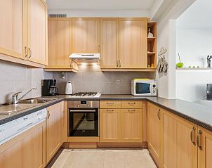 Modern kitchen in vacation home Azcona Twee, Koksijde, West Flanders, Belgium with wooden cabinets and modern appliances.