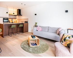 Stilvolles Wohnzimmer des Ferienhauses La Balise Third in Koksijde, Belgien, mit moderner Kche und gemtlicher Sitzecke.