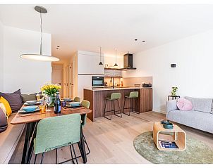 Stilvolles Wohnzimmer und Kche des Ferienhauses La Balise Third in Koksijde, Westflandern, mit moderner Einrichtung und gemtlicher Sitzecke.