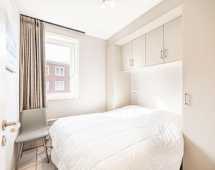 Attraktives Schlafzimmer im Ferienhaus Delfien First, Koksijde, mit heller Einrichtung und Blick auf die Umgebung von Westflandern, Belgien.