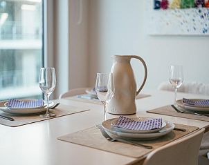 Helles Esszimmer im dritten Ferienhaus De Dijk in Koksijde, Westflandern, mit moderner Einrichtung und Stadtblick.