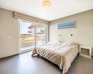 Helles Schlafzimmer in Tinou Ferienhaus im Erdgeschoss, Koksijde, Westflandern, mit Zugang zur Terrasse und Blick auf die Natur.