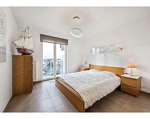 Schlafzimmer des vierten Ferienhauses Delmar in Koksijde, Westflandern, mit moderner Einrichtung und Blick auf die Umgebung.