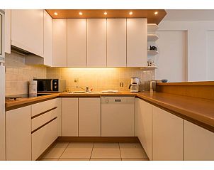 Moderne Kche im zweiten Ferienhaus von Les Petrels, Koksijde, Westflandern, Belgien, mit stilvoller Beleuchtung und schlichten weien Schrnken.