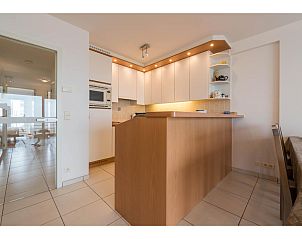 Moderne Kche im Ferienhaus Les Petrels second in Koksijde, Westflandern, mit stilvoller Holzbar und eingebauter Beleuchtung.