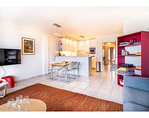 Modernes Wohnzimmer im vierten Ferienhaus von Les Petrels, Koksijde, mit offener Kche und farbenfroher Einrichtung in Westflandern, Belgien.