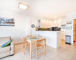 Bright interior of vacation home Les Petrels sixth in Koksijde, West Flanders, with modern kitchen and cozy dining area.