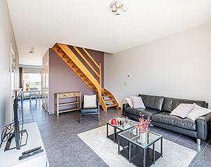Stylish living room of vacation home Lysa fourth in Koksijde, West Flanders, with modern furnishings and wooden staircase.