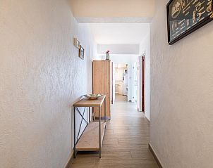 Helle Diele im Ferienhaus Neva Cinq, Koksijde, Westflandern, Belgien, mit Holzmbeln und moderner Einrichtung.