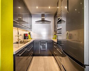 Modern kitchen in vacation home Zeezicht GV, Koksijde, West Flanders. Stylish decor with stainless steel appliances and bright accents.