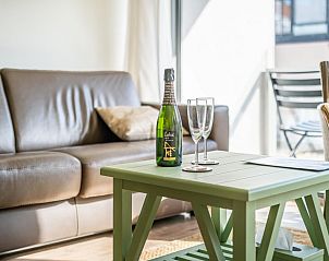 Entspanntes Wohnzimmer des Ferienhauses CityZen in Koksijde, Westflandern, mit bequemem Sofa und einladender Sitzecke.