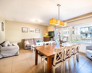 Gemtliches Wohnzimmer des Ferienhauses Argenteuil in Koksijde, Westflandern, mit groem Esstisch und Stadtblick.