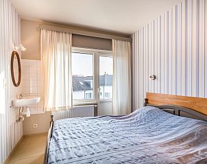 Schlafzimmer im Ferienhaus Argenteuil in Koksijde, Westflandern mit bequemem Bett und natrlichem Licht durch groe Fenster.