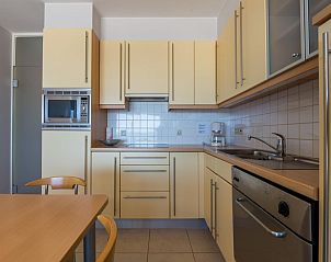 Moderne Kche im Ferienhaus Duinzicht fifth, Koksijde, Westflandern, mit eleganten Holzschrnken und kompletter Ausstattung.