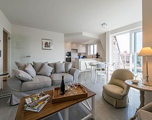 Helles Wohnzimmer des zweiten Ferienhauses Bon Accueil in Koksijde, Westflandern, mit moderner Einrichtung und Blick auf die Terrasse.