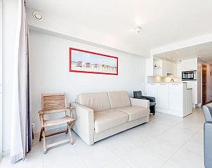 Helles Wohnzimmer des vierten Ferienhauses Aan de Dijk in Koksijde, Belgien, mit modernen Mbeln und offener Kche.