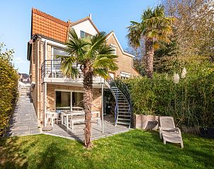 Le Palmier vakantiehuis in Koksijde, West-Vlaanderen met zonnig terras, omgeven door palmbomen en groene tuin, ideaal voor ontspanning.