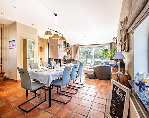 Ruime eetkamer in vakantiehuis Le Palmier in Koksijde, West-Vlaanderen, met uitzicht op tuin en comfortabele inrichting.