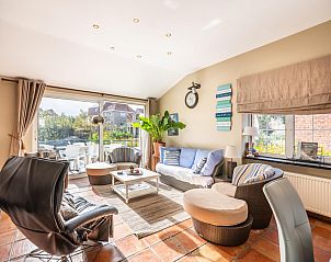 Gezellige woonkamer van vakantiehuis Le Palmier in Koksijde, West-Vlaanderen, met zonovergoten terras en moderne inrichting.