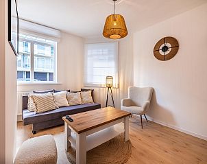 Stijlvolle woonkamer in vakantiehuis Ensemble in Koksijde, West-Vlaanderen. Gezellige zithoek met moderne inrichting en natuurlijke lichtinval.